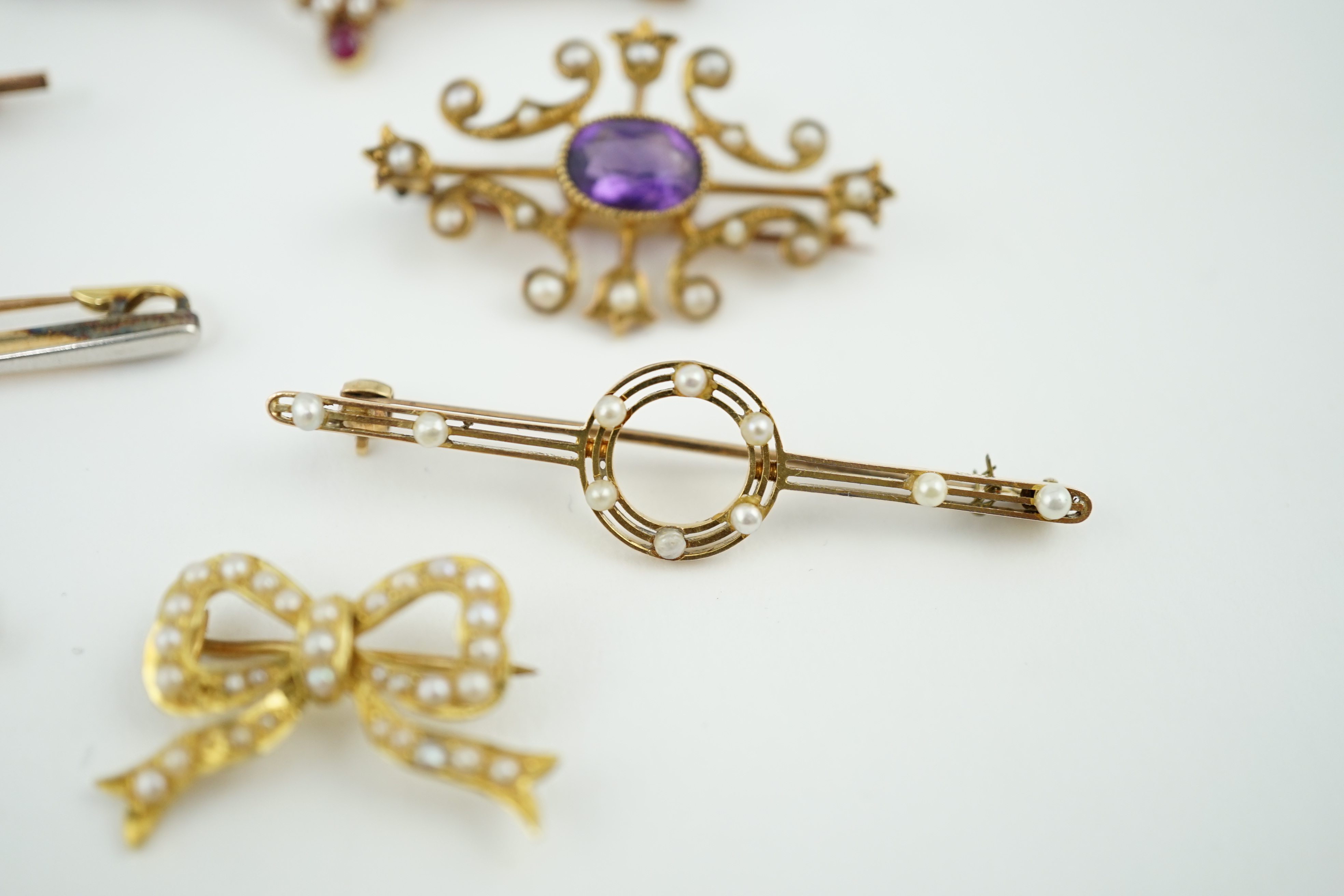 Five assorted Edwardian bar brooches, including a 15ct gold sapphire and diamond set three stone, a diamond and seed pearl, ruby? and seed pearl, a solitaire diamond set and a seed pearl and citrine bug brooch